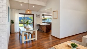 Eine moderne Küche mit Bar, Holzboden und großen Fenstern mit Blick ins Freie.