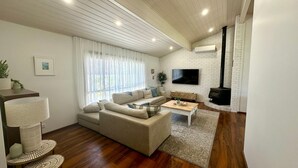 Een moderne woonkamer met een bank, salontafel en een open haard.