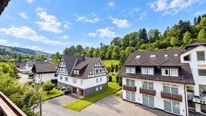 A residential area with traditional half-timbered houses, paved streets, and a green landscape. - A comfortable and versatile room—perfect for relaxation, work, and socializing (Winterberg)