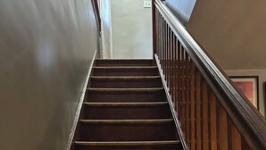 A wooden staircase with a handrail, leading up to a landing. - Pittsburgh city views close to all, cozy & bright 1BR - King + Dedicated Office (Pittsburgh)