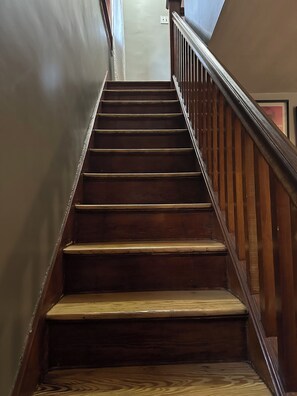 A wooden staircase with a handrail, leading up to a landing. - Pittsburgh city views close to all, cozy & bright 1BR - King + Dedicated Office (Pittsburgh)