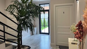 A modern interior with a staircase, a large potted plant, and a door with the number 1. - Haya (Kanakeravan)