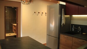 Una cucina moderna con frigorifero in acciaio inossidabile, pensili in legno e piano di lavoro scuro.