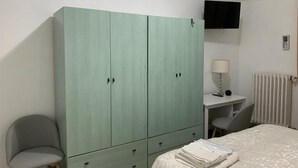 A bedroom with a bed, a desk, a chair, and a wardrobe. - Deluxe Room – ALH Hotel Digitale (Taranto)