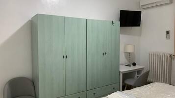 1 habitación, escritorio y tabla de planchar con plancha