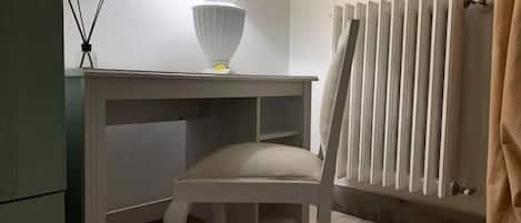 1 habitación, escritorio y tabla de planchar con plancha