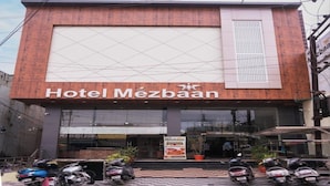 Hotel Mezbaan with a large sign, a covered entrance, and several parked scooters in front. - Hotel Mezbaan  (Raipur)