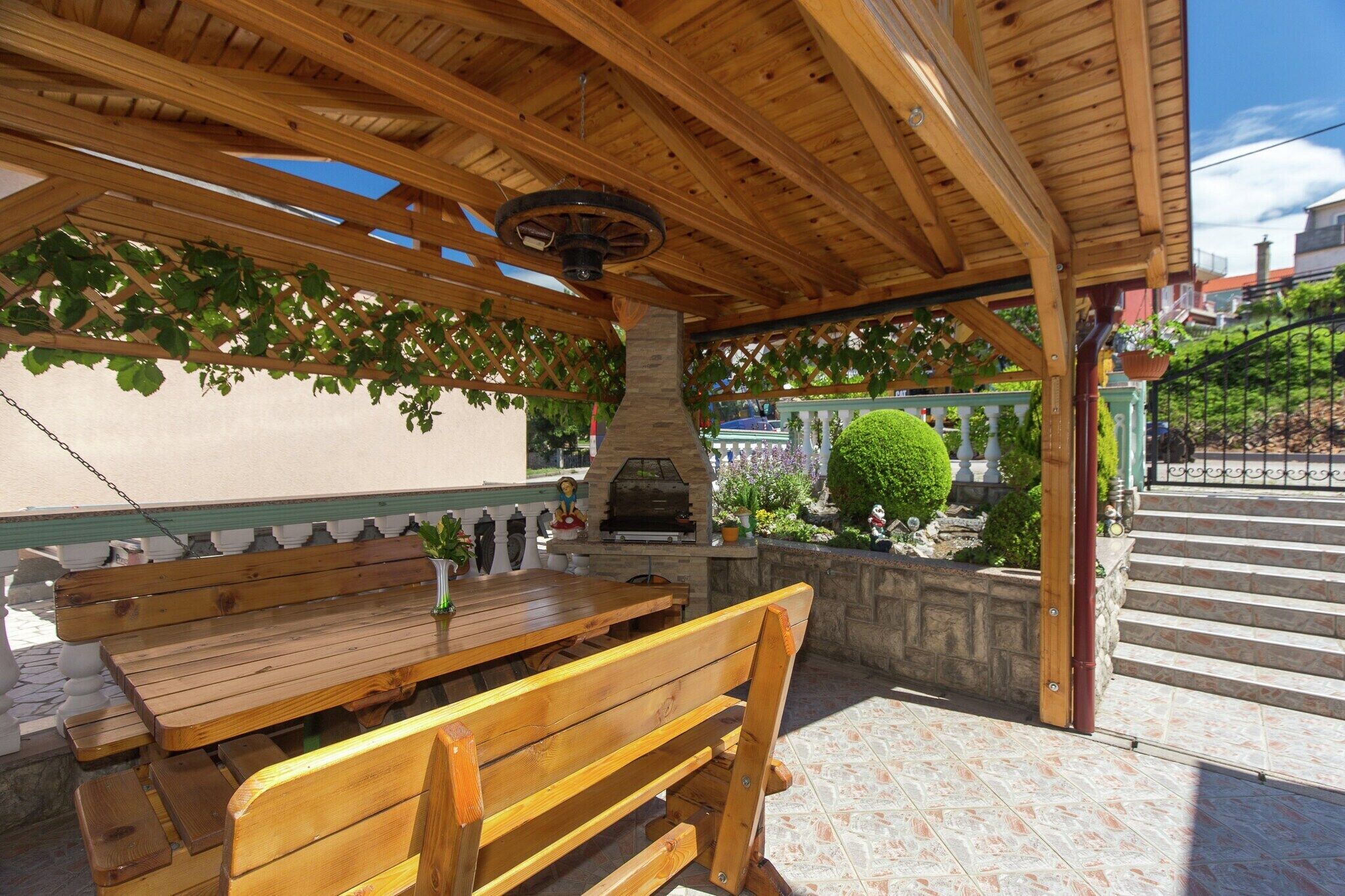 An outdoor patio with wooden benches and a stone wall.