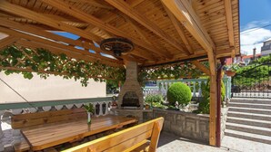 Une terrasse extérieure avec des bancs en bois et un mur en pierre.