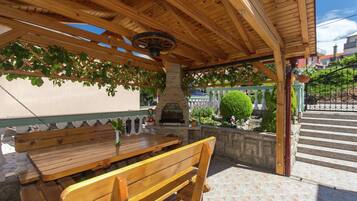 An outdoor patio with wooden benches and a stone wall.