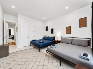 Une chambre moderne avec deux lits, une armoire et une petite table de chevet.