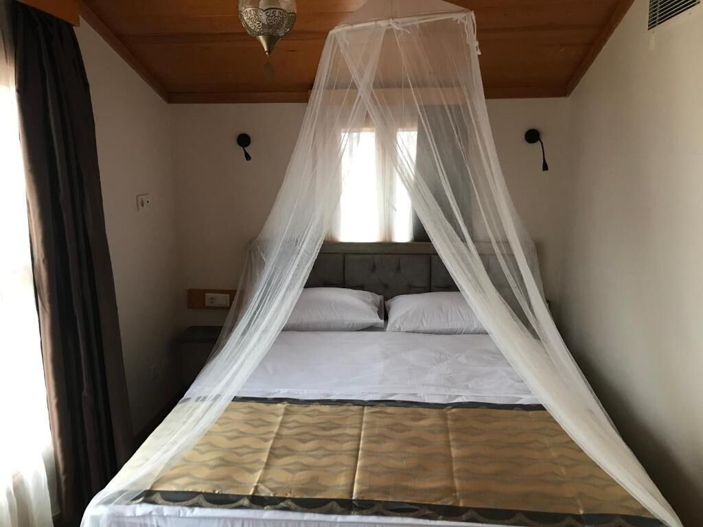 A bed with a canopy, a headboard, and two bedside tables.