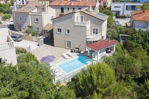 A residential building with a swimming pool, multiple balconies, and a garden area.