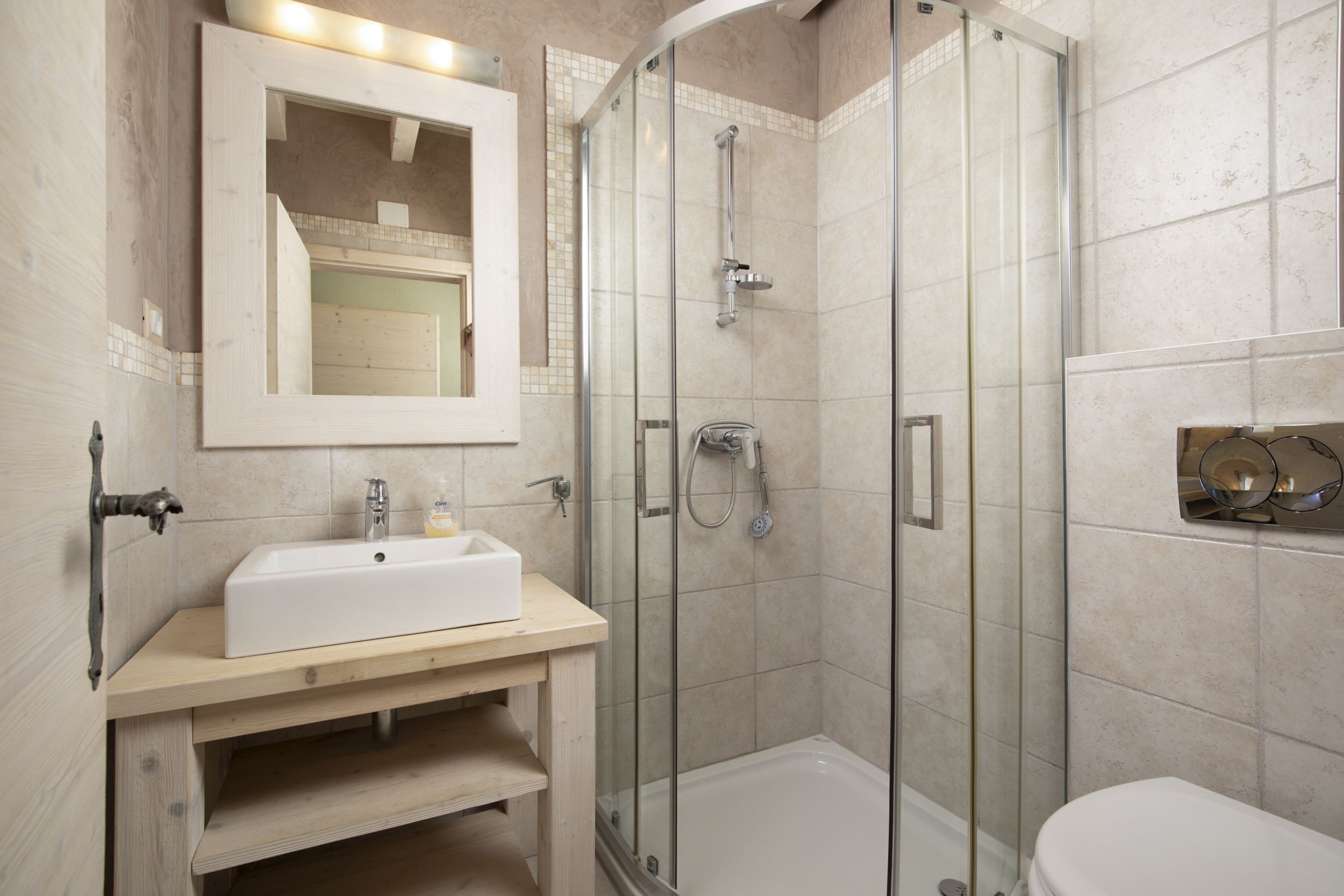 A modern bathroom with a glass-enclosed shower, a white sink, and a toilet.