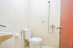 Bathroom features a toilet, shower, and sink.