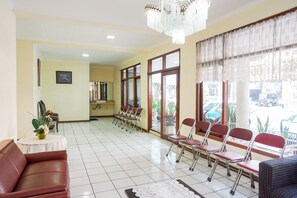 Relax in our spacious lobby with a seating area, large window, and elegant chandelier.