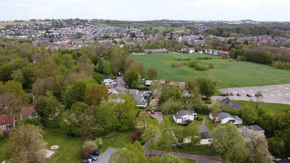 An aerial view of a residential area with houses, a large green field, and a church.
