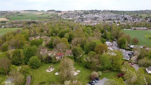 An aerial view of a residential area with houses, green fields, and a small village in the background. - Bungalowpark Simpelveld - Schakel 5 (Simpelveld)