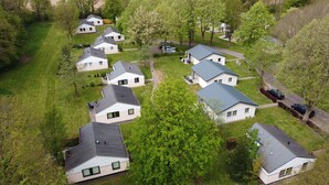 Zona residencial con varias casas, cada una con un estilo de techo diferente y rodeada de vegetación.