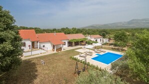 Une villa avec piscine, plusieurs pièces et un jardin.