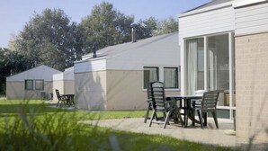 A modern, single-story mobile home with a patio area featuring a table and chairs. - Bungalowpark Simpelveld - Castra 47 (Simpelveld)