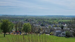 A residential area with houses, a playground, and wind turbines in the distance. - Bungalowpark Simpelveld - Castra 47 (Simpelveld)