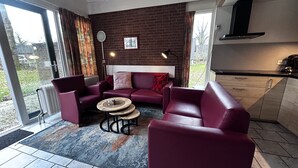 Un soggiorno moderno con un divano rosso, un tavolino da caffè e vista sull'esterno.
