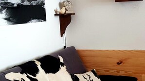 A bedroom with a bed, a mounted picture of a mountain, a wall clock, a lamp, and a wooden headboard. - Balcons B 011 - Parc Nat. Vanoise Appart. 6 Pers (Val-Cenis)