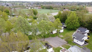 Een woonwijk met huizen, groene gazons en bomen.