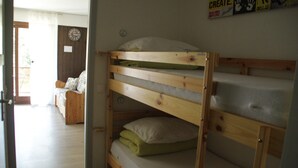 Een stapelbed met houten frame, matras en kussen.