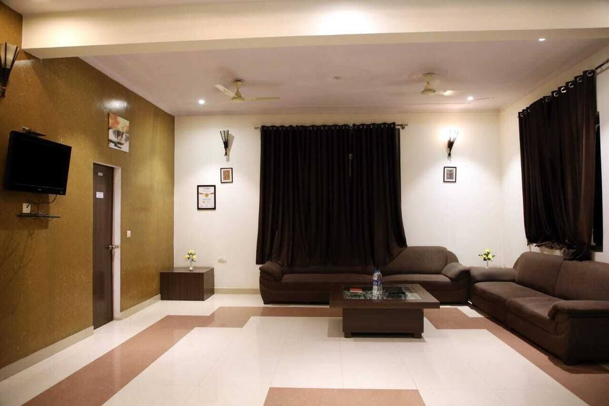 A living room with two sofas, a coffee table, and a TV mounted on the wall.