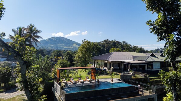 Un complexe hôtelier doté d’une piscine, de chaises longues et offrant une vue sur les montagnes.