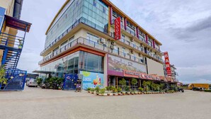 A multi-story building with a prominent bar and restaurant on the ground floor, a visible staircase, and a sign for a hotel. - IROOMZ Eco - HOTEL BIG BOSS (Chitradurga)