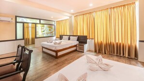 A hotel room with a bed, a TV, a desk, and a chair. There is a window with curtains and a view of the outside. - IROOMZ Eco - HOTEL BIG BOSS (Chitradurga)