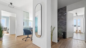 Una habitación amplia con un espejo grande, suelo de madera y una pared de acento de piedra.