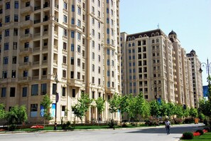 A multi-story hotel with balconies, a central courtyard, and a street view.
