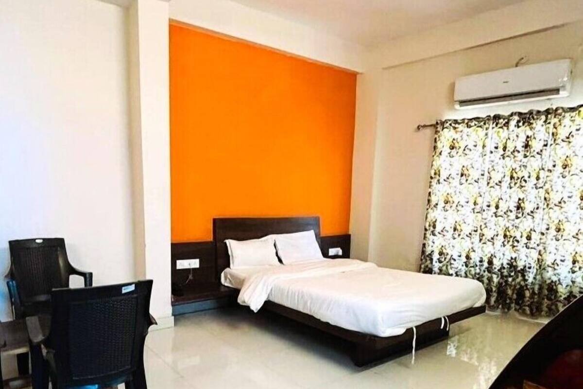 A hotel room with a bed, a desk, and a chair.