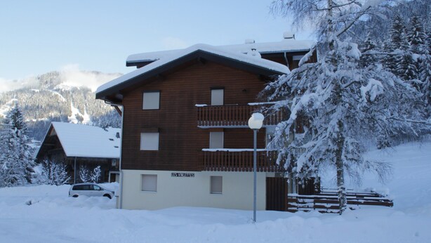 Un bâtiment en bois doté d’un balcon et d’une enseigne sur laquelle on peut lire « LES VIOLETTES ».