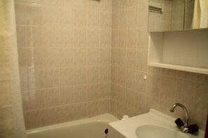 Ein Badezimmer mit Badewanne, Waschbecken und einem Spiegel darüber.