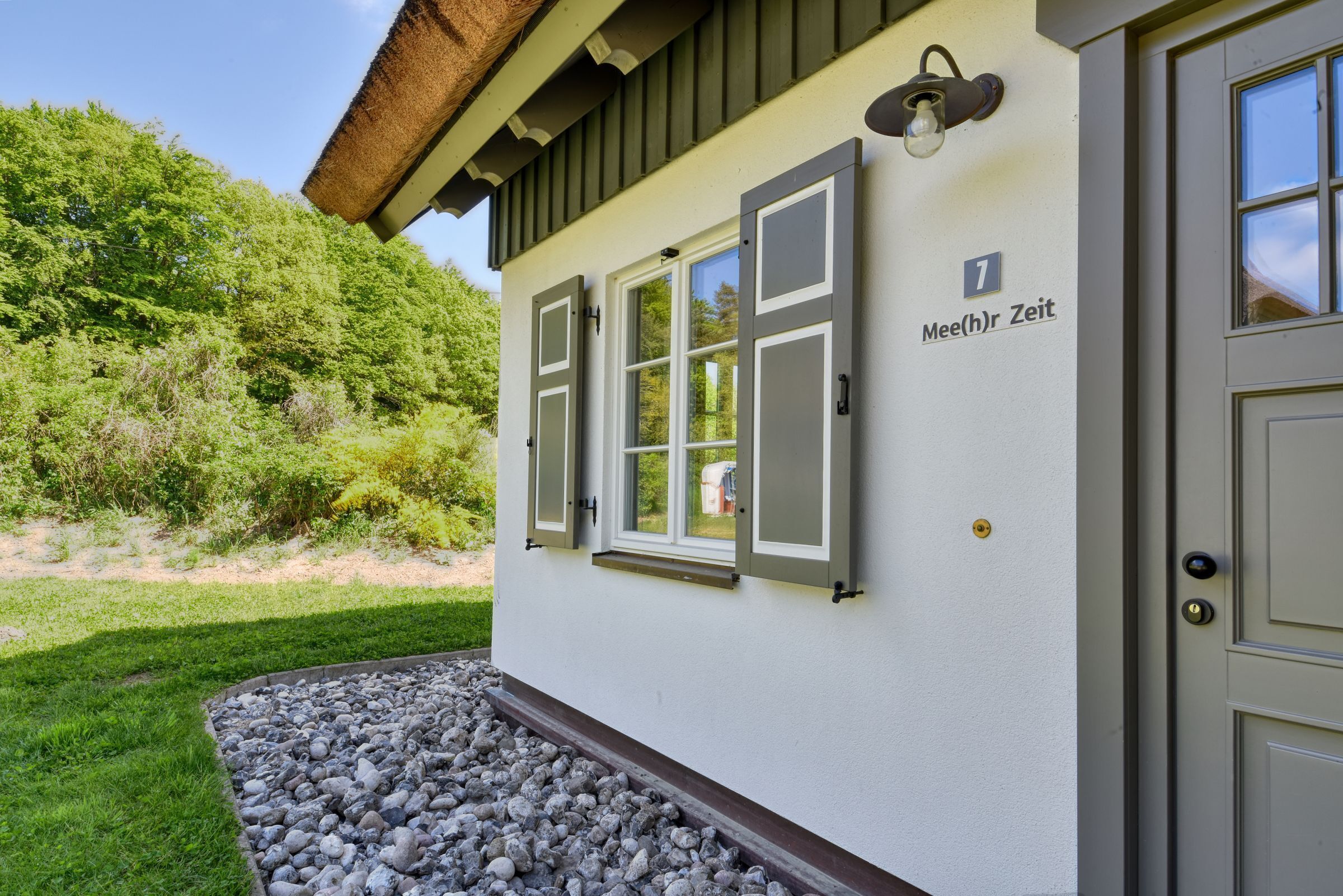 Un bâtiment avec une porte portant le numéro « 1 » et une fenêtre avec des volets.