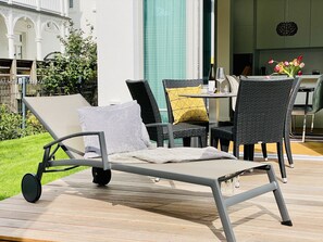 Relax in style with a lounge chair and ottoman on the spacious deck, perfect for dining or socializing.