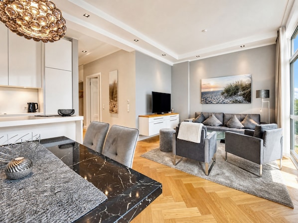 A modern living room with a sofa, TV, and artwork.