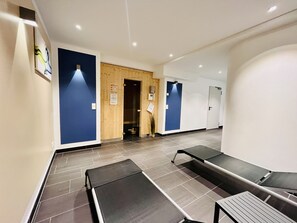 A reception area with a wooden door, a reception desk, and a waiting area with benches. - Light-flooded vacation apartment 'Lachmöwe' in Baabe: sea view, comfort (Baabe)