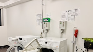 Een wasserette met twee voorladers, een groene zeepdispenser en een rode brandblusser.