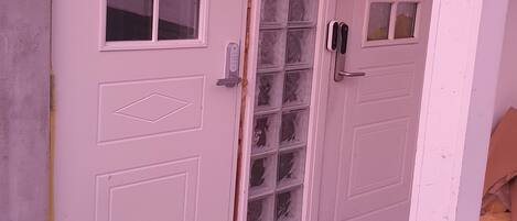 A white door with a window and a keypad lock.