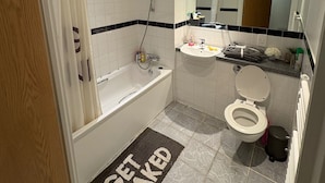 Ein modernes Badezimmer mit Badewanne, Toilette und Waschbecken.