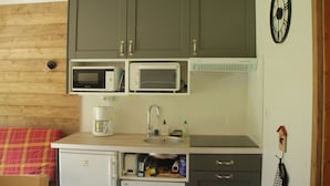 A compact kitchenette with a microwave, coffee maker, and sink. - Christina CR8 Family & Mountain 6 Pers (Chatel)