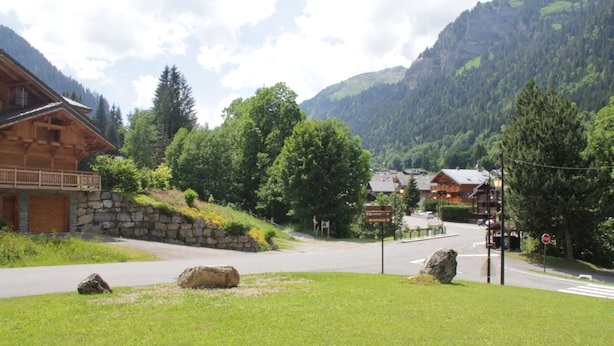 A wooden building with a stone facade, a stone wall, and a grassy area with rocks. - Christina CR8 Family & Mountain 6 Pers (Chatel)