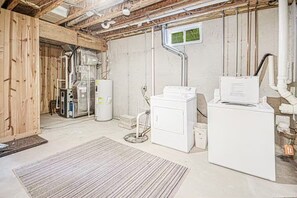 A laundry room with a washing machine, dryer, and water heater. - Hidden Dunes #11 (Saugatuck)