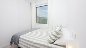 A bedroom with a bed, a window, and a view of the outdoors. - Overlooking the sea! New apt. with terrace 3 bedrooms+2 bathrooms&community pool (Los Caños de Meca)